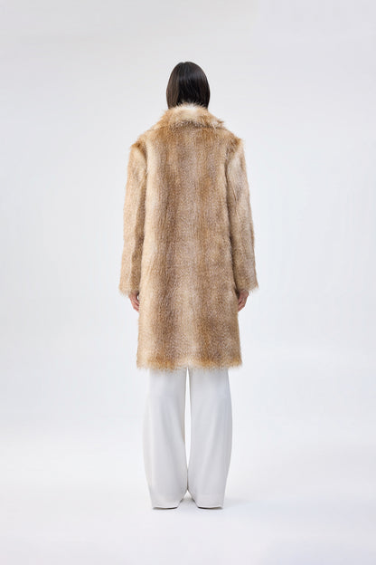 back view of a person wearing a faux fur coat and white pants on a white background