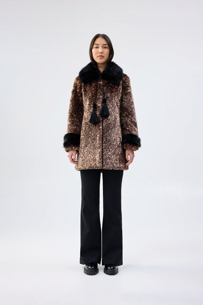 Person wearing a patterned coat with faux fur trim on a white background