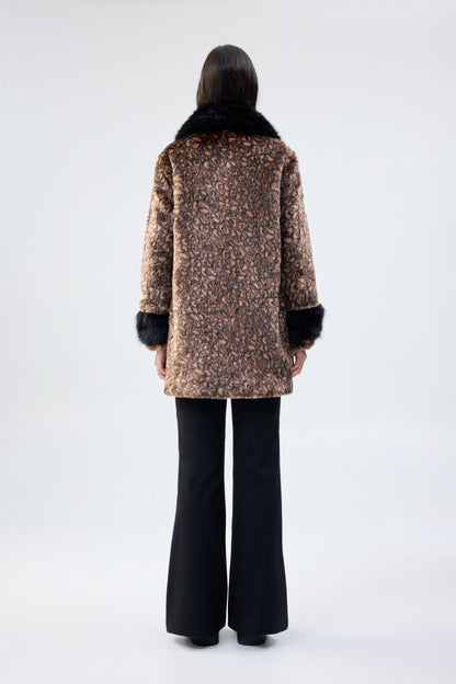 Person wearing a patterned coat with faux fur trim on a white background